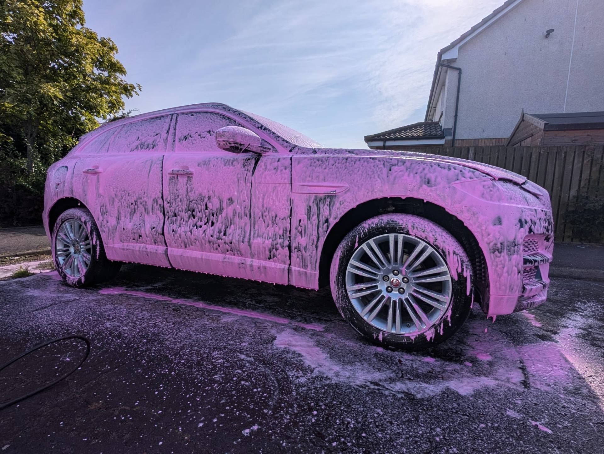 Jaguar covered in pink snow foam - professional mobile valeting Glasgow